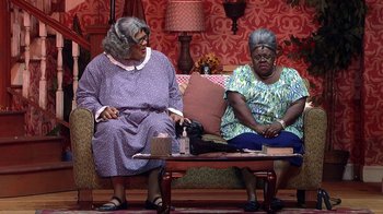 Movie still from “Madea on the Run” (2017), directed by Derrick Doose – A couple of women sitting next to each other on top of a couch; Wide shot, High angle