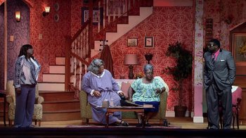 Movie still from “Madea on the Run” (2017), directed by Derrick Doose – A couple of people sitting on top of couches on a stage; Wide shot, High angle