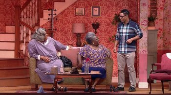 Movie still from “Madea on the Run” (2017), directed by Derrick Doose – A group of people standing around a living room together; Wide shot, High angle