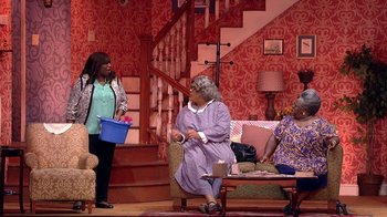 Movie still from “Madea on the Run” (2017), directed by Derrick Doose – A group of people sitting on top of a wooden bench; Wide shot, High angle