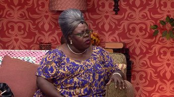 Movie still from “Madea on the Run” (2017), directed by Derrick Doose – An older woman sitting on a chair in a room; Medium shot, Over the shoulder angle