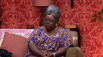 Movie still from “Madea on the Run” (2017), directed by Derrick Doose – A woman sitting on top of a couch in a living room; Medium shot, Over the shoulder angle