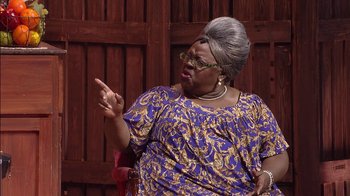 Movie still from “Madea on the Run” (2017), directed by Derrick Doose – An older woman wearing a blue and yellow dress; Medium shot, Over the shoulder angle