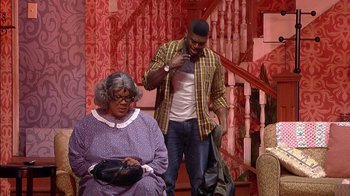 Movie still from “Madea on the Run” (2017), directed by Derrick Doose – A man and a woman standing next to each other on a stage; Wide shot, Over the shoulder angle