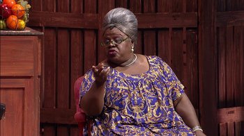 Movie still from “Madea on the Run” (2017), directed by Derrick Doose – An older woman sitting in a chair wearing a blue dress; Medium shot, Low angle