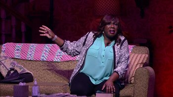 Movie still from “Madea on the Run” (2017), directed by Derrick Doose – A woman sitting on a couch with her arms outstreched; Medium shot, Over the shoulder angle
