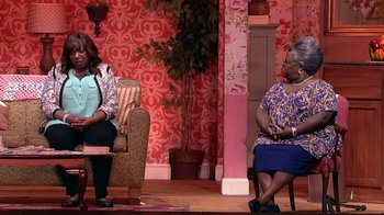Movie still from “Madea on the Run” (2017), directed by Derrick Doose – Two women sitting on chairs on a stage; Medium shot, Over the shoulder angle