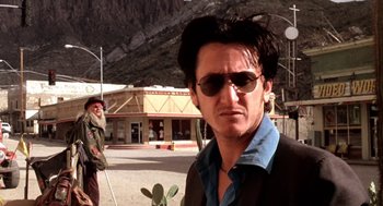 Movie still from “U Turn” (1997), directed by Oliver Stone – A man with sunglasses and a cactus in the street; Close Up shot, Low angle