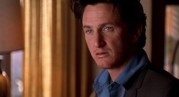 Movie still from “U Turn” (1997), directed by Oliver Stone – A person wearing a suit and tie; Close Up shot, Over the shoulder angle