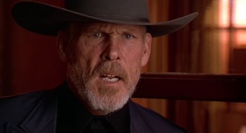 Movie still from “U Turn” (1997), directed by Oliver Stone – An older man wearing a cowboy hat and a suit; Close Up shot, Low angle
