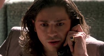 Movie still from “U Turn” (1997), directed by Oliver Stone – A person talking on a cell phone; Close Up shot, Low angle