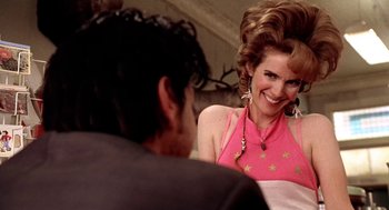 Movie still from “U Turn” (1997), directed by Oliver Stone – A man and a woman sitting on a couch talking to each other; Close Up shot, Over the shoulder angle