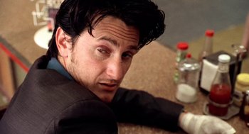 Movie still from “U Turn” (1997), directed by Oliver Stone – A person sitting on the ground; Close Up shot, Low angle