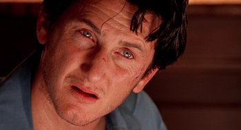 Movie still from “U Turn” (1997), directed by Oliver Stone – A man's face with blue eyes; Close Up shot, Low angle