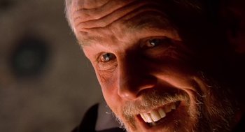 Movie still from “U Turn” (1997), directed by Oliver Stone – An old man with a beard and a goatee smiling for the camera; Extreme Close Up shot, Low angle