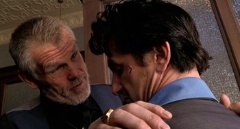 Movie still from “U Turn” (1997), directed by Oliver Stone – A man with a bandaged eye is looking at another man with a bandaged eye; Close Up shot, Over the shoulder angle