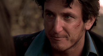 Movie still from “U Turn” (1997), directed by Oliver Stone – A person with a beard; Close Up shot, Over the shoulder angle