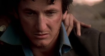 Movie still from “U Turn” (1997), directed by Oliver Stone – A man's face with his hand on his shoulder; Close Up shot, Low angle