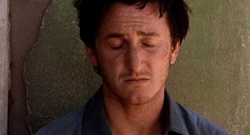 Movie still from “U Turn” (1997), directed by Oliver Stone – A person with his eyes closed; Close Up shot, High angle