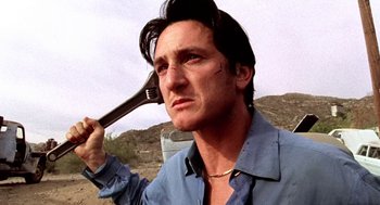 Movie still from “U Turn” (1997), directed by Oliver Stone – A man holding a fork up to his head; Close Up shot, Low angle