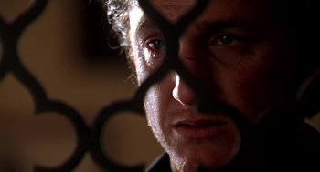 Movie still from “U Turn” (1997), directed by Oliver Stone – A man's face behind a pair of scissors; Extreme Close Up shot, Low angle