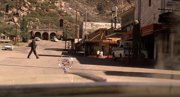 Movie still from “U Turn” (1997), directed by Oliver Stone – A view of a street from a car window; Extreme Wide shot, Low angle