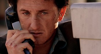 Movie still from “U Turn” (1997), directed by Oliver Stone – A person holding a cell phone; Close Up shot, Low angle