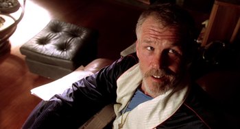 Movie still from “U Turn” (1997), directed by Oliver Stone – A person sitting on a couch; Close Up shot, Low angle