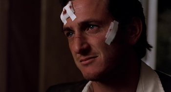Movie still from “U Turn” (1997), directed by Oliver Stone – A person with stickers on his face; Close Up shot, Low angle