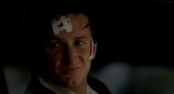 Movie still from “U Turn” (1997), directed by Oliver Stone – A person with a sticker on his forehead; Close Up shot, Low angle