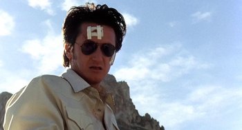 Movie still from “U Turn” (1997), directed by Oliver Stone – A man with a sticker on his forehead; Close Up shot, Low angle