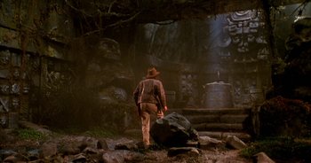 Movie still from “UHF” (1989), directed by Jay Levey – A man in a cowboy hat walking through a forest; Wide shot, Low angle