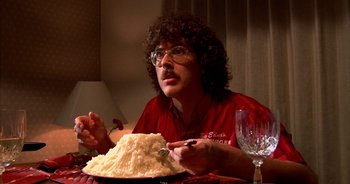 Movie still from “UHF” (1989), directed by Jay Levey – A man sitting in front of a plate of cake; Close Up shot, Over the shoulder angle