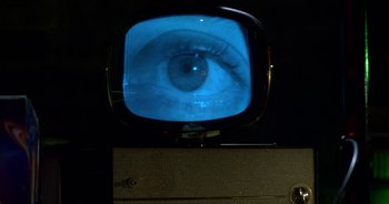 Movie still from “UHF” (1989), directed by Jay Levey – An old television with a picture of an eye on it; Extreme Close Up shot, Overhead angle