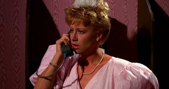 Movie still from “UHF” (1989), directed by Jay Levey – A woman in a tiara talking on a phone; Close Up shot, High angle