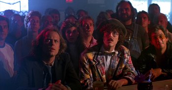 Movie still from “UHF” (1989), directed by Jay Levey – A group of people sitting in front of each other; Medium shot, Over the shoulder angle