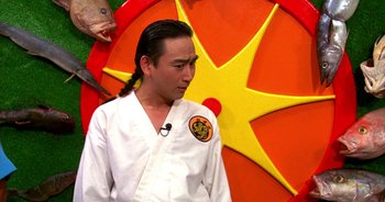 Movie still from “UHF” (1989), directed by Jay Levey – A man in a karate outfit standing in front of a wall; Close Up shot, Over the shoulder angle