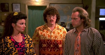 Movie still from “UHF” (1989), directed by Jay Levey – A group of men standing next to each other; Medium shot, Over the shoulder angle