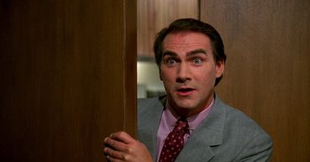 Movie still from “UHF” (1989), directed by Jay Levey – A person wearing a suit and tie; Close Up shot, Low angle