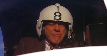 Movie still from “UHF” (1989), directed by Jay Levey – A person wearing a suit and a helmet; Close Up shot, Low angle