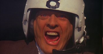 Movie still from “UHF” (1989), directed by Jay Levey – A man's face with a motorcycle helmet on; Close Up shot, Overhead angle