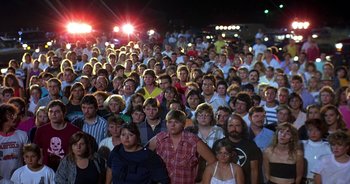 Movie still from “UHF” (1989), directed by Jay Levey – A crowd of people standing in front of a building; Wide shot, High angle