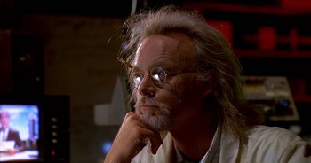 Movie still from “UHF” (1989), directed by Jay Levey – An older man with glasses is sitting with his hand under his chin; Close Up shot, Low angle