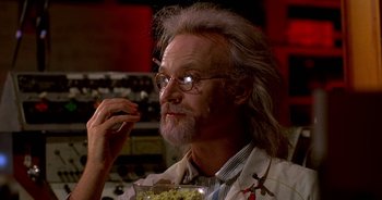 Movie still from “UHF” (1989), directed by Jay Levey – An old man with a beard and glasses eating a bowl of macaroni and cheese; Close Up shot, Low angle