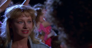 Movie still from “UHF” (1989), directed by Jay Levey – A person wearing a jean jacket; Close Up shot, Over the shoulder angle