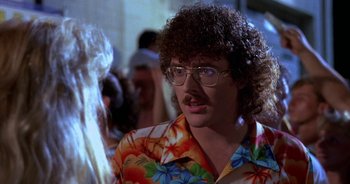 Movie still from “UHF” (1989), directed by Jay Levey – A man in a hawaiian shirt with a mustache; Close Up shot, Over the shoulder angle