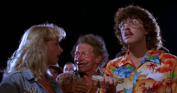 Movie still from “UHF” (1989), directed by Jay Levey – A group of people that are standing up; Medium shot, Low angle
