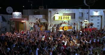 Movie still from “UHF” (1989), directed by Jay Levey – A large crowd of people in front of a building; Extreme Wide shot, High angle