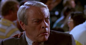 Movie still from “UHF” (1989), directed by Jay Levey – An older man in a suit and tie looking angry; Close Up shot, Low angle