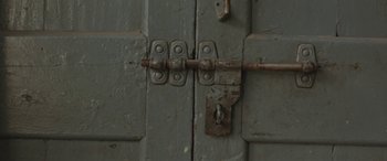 Movie still from “Udta Punjab” (2016), directed by Abhishek Chaubey – An old wooden door with a metal latch and lock; Extreme Close Up shot, Overhead angle